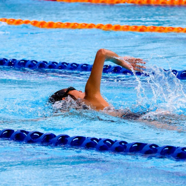 person swimming on an olympic pool